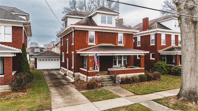 american foursquare style home with a porch, brick siding, an outdoor structure, and a detached garage