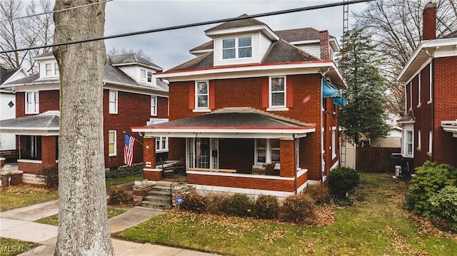 american foursquare style home with covered porch and brick siding