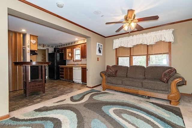 living area with a ceiling fan, stone finish flooring, baseboards, and crown molding