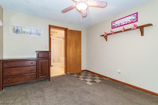 carpeted bedroom with ceiling fan, ensuite bath, and baseboards