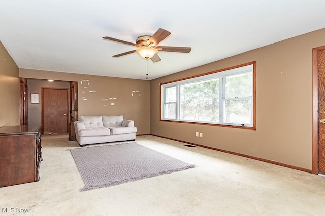 unfurnished living room featuring ceiling fan, light colored carpet, visible vents, and baseboards