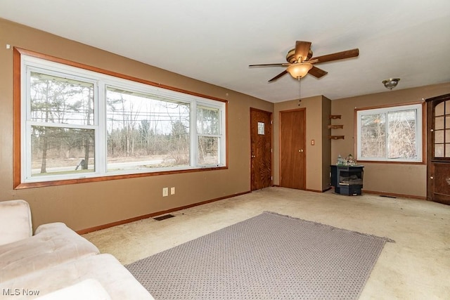 carpeted living area featuring baseboards, visible vents, and a ceiling fan