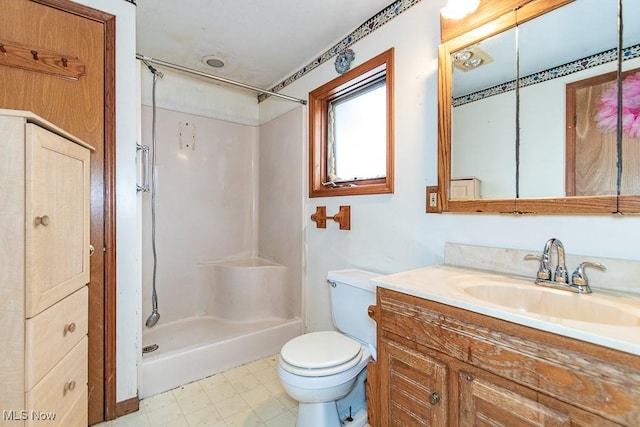 full bathroom with toilet, vanity, walk in shower, and tile patterned floors