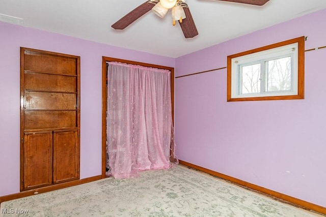 unfurnished bedroom featuring carpet floors, baseboards, and a ceiling fan