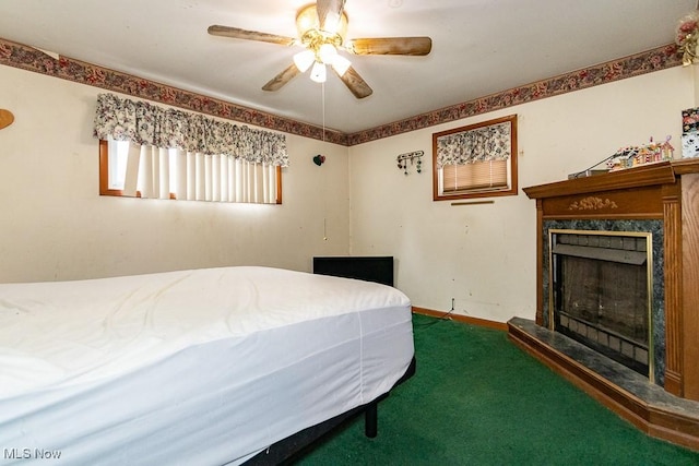 bedroom with a premium fireplace, carpet flooring, a ceiling fan, and baseboards