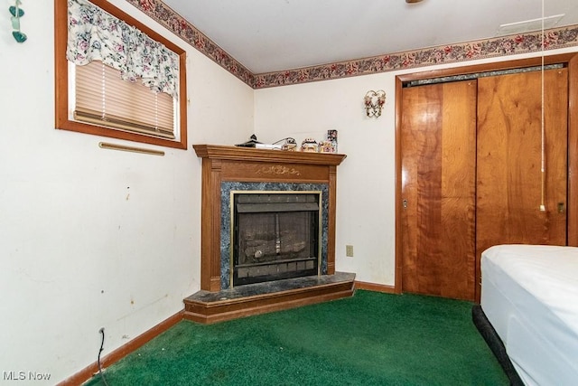 carpeted bedroom with baseboards and a high end fireplace