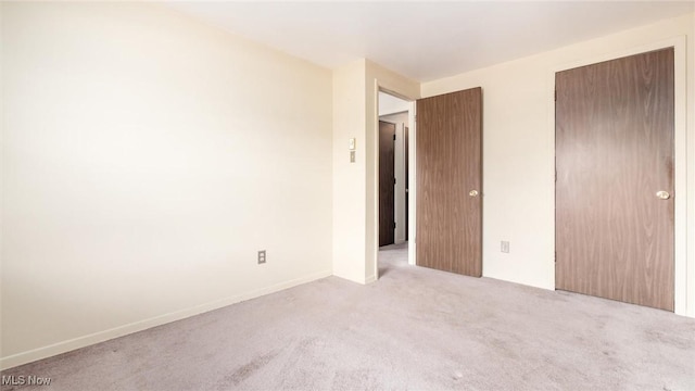unfurnished bedroom featuring a closet, carpet flooring, and baseboards