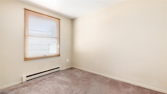 carpeted spare room with a baseboard heating unit and baseboards