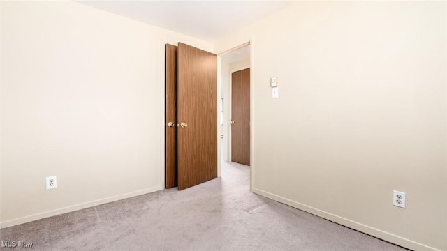 empty room featuring carpet flooring and baseboards