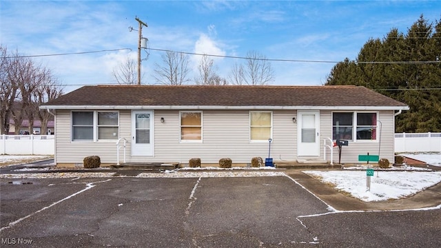 single story home with entry steps, uncovered parking, and fence