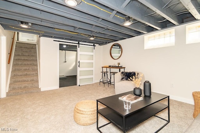 living room with a barn door, stairway, and carpet flooring