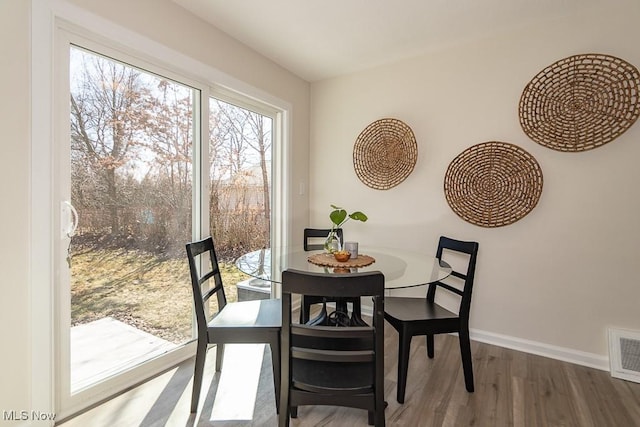 dining space featuring visible vents, baseboards, and wood finished floors