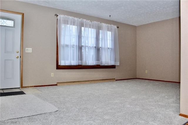 foyer with carpet, a textured ceiling, baseboards, and baseboard heating