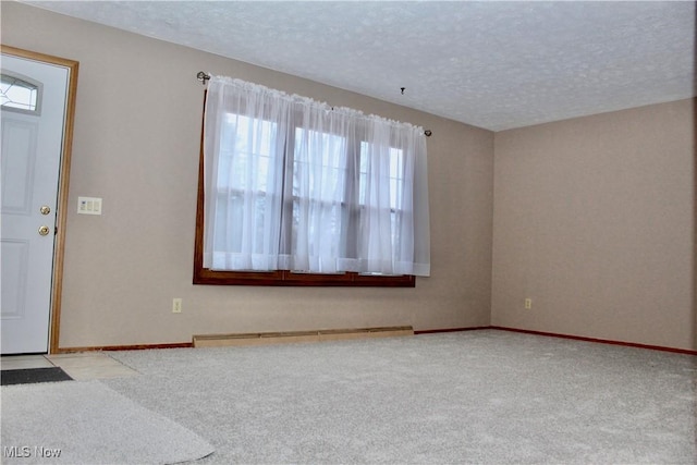 carpeted entryway with a baseboard radiator, baseboards, and a textured ceiling