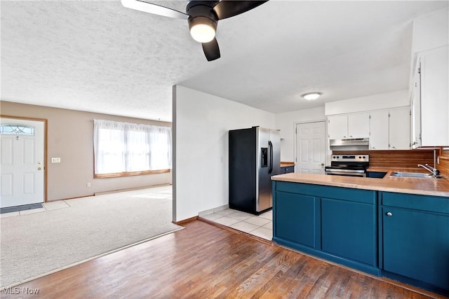 kitchen featuring blue cabinets, a sink, white cabinetry, refrigerator with ice dispenser, and stainless steel electric range oven