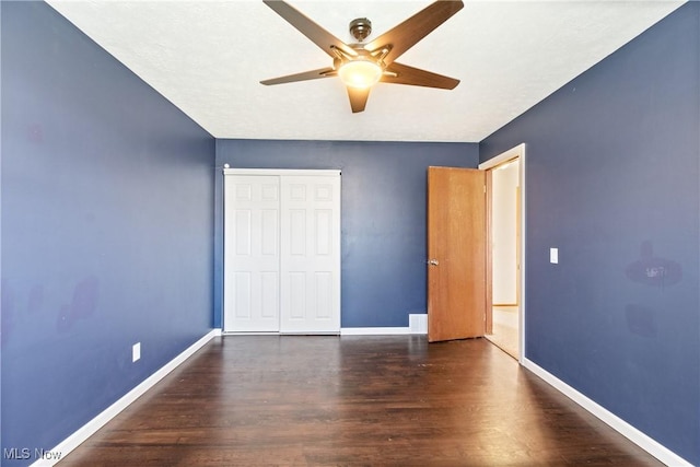 unfurnished bedroom with a closet, baseboards, and wood finished floors