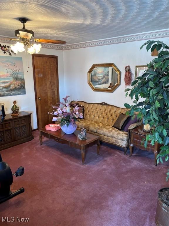 carpeted living area featuring a ceiling fan