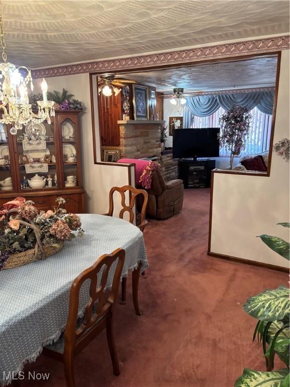 carpeted dining area featuring ceiling fan with notable chandelier