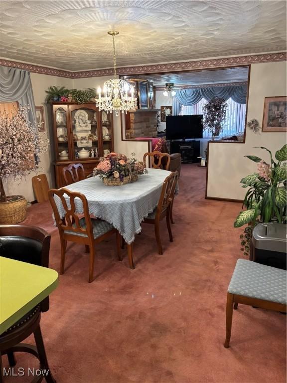 carpeted dining space featuring a notable chandelier