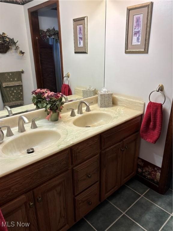 full bathroom with double vanity, tile patterned flooring, and a sink