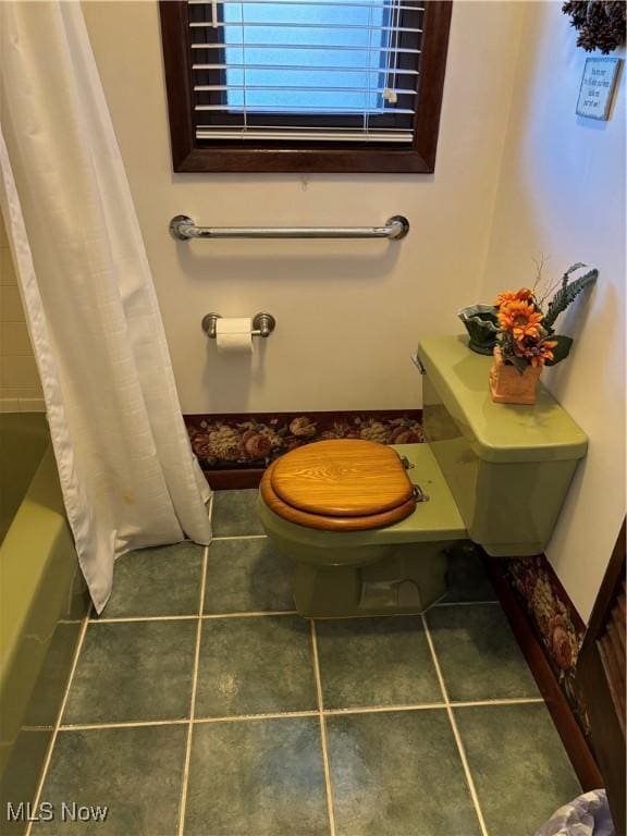 full bathroom with toilet, tile patterned flooring, and shower / bath combination with curtain