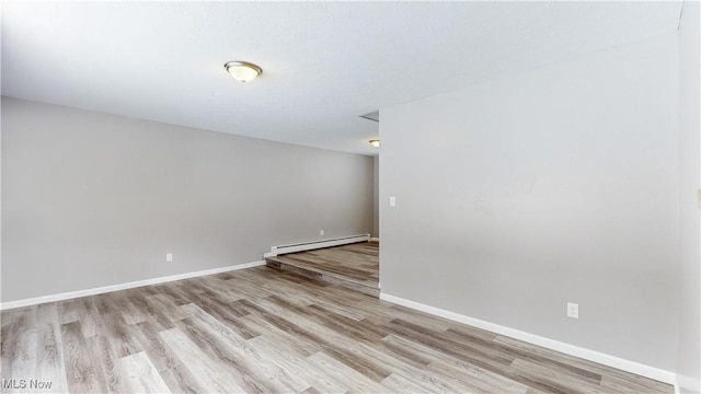 unfurnished room with light wood-type flooring, a baseboard radiator, and baseboards