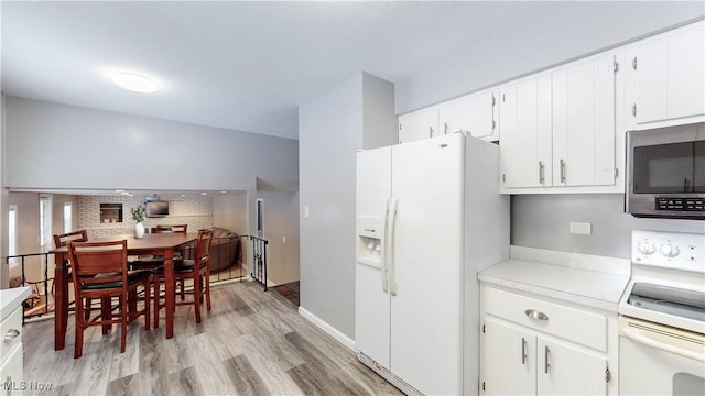 kitchen featuring white appliances, white cabinetry, light countertops, light wood-type flooring, and tasteful backsplash