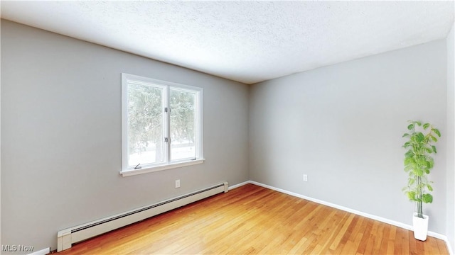 unfurnished room with baseboards, a textured ceiling, baseboard heating, and wood finished floors