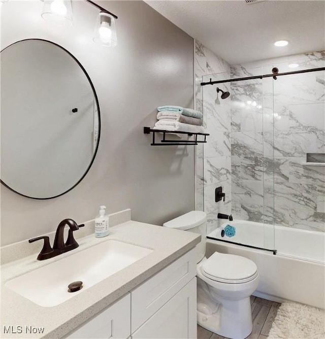 full bath with toilet, shower / bath combination with glass door, and vanity