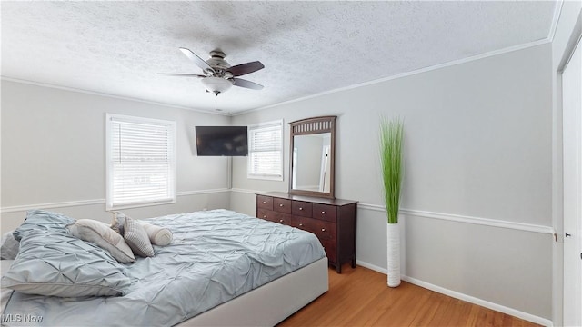 bedroom with crown molding, a textured ceiling, and wood finished floors