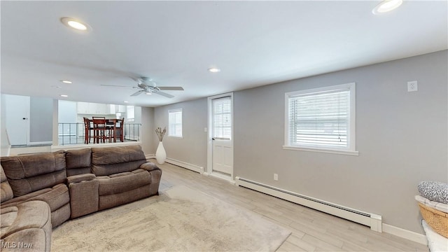 living room featuring baseboards, a baseboard radiator, wood finished floors, and recessed lighting