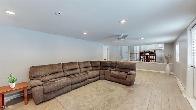 living area featuring baseboards, ceiling fan, recessed lighting, and light wood-style floors