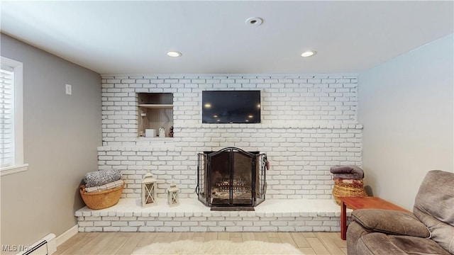 living area with a brick fireplace, baseboard heating, wood finished floors, and recessed lighting