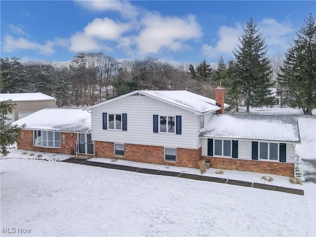 view of front of house featuring brick siding and a chimney