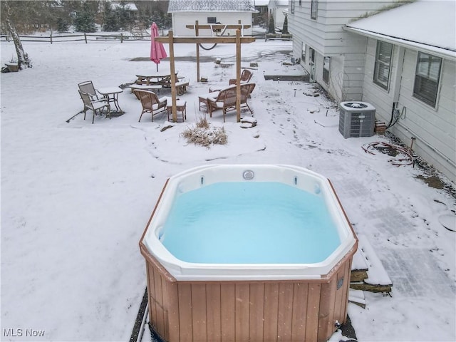 exterior space with a hot tub, a fire pit, and cooling unit