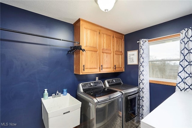 clothes washing area featuring cabinet space, separate washer and dryer, and a sink