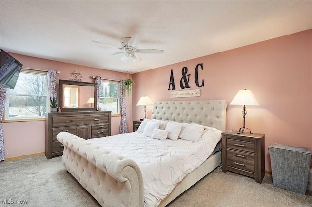 bedroom with light colored carpet, ceiling fan, and baseboards