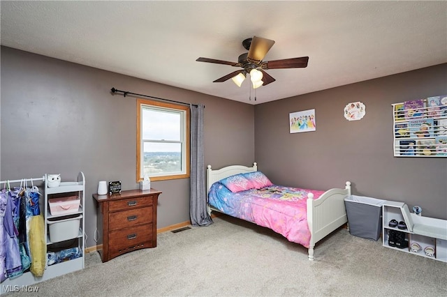 carpeted bedroom featuring ceiling fan, visible vents, and baseboards