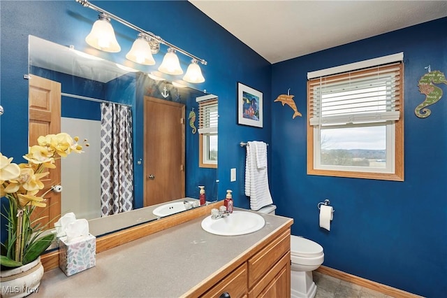 bathroom featuring toilet, a shower with curtain, baseboards, and vanity