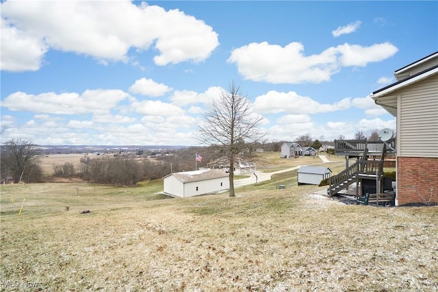 view of yard featuring an outdoor structure, a deck, and stairs