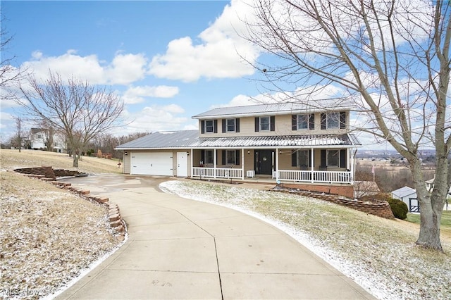 view of front of property featuring covered porch, an attached garage, concrete driveway, and metal roof