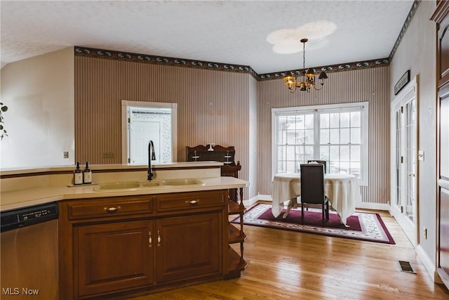 kitchen featuring visible vents, light wood-type flooring, stainless steel dishwasher, a chandelier, and a sink