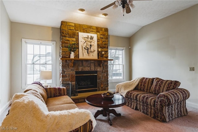 living area featuring carpet floors, a fireplace, a ceiling fan, baseboards, and vaulted ceiling