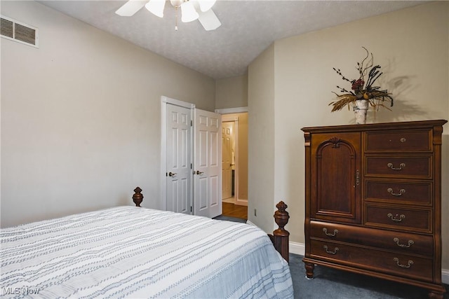 bedroom featuring ceiling fan, dark carpet, visible vents, and baseboards