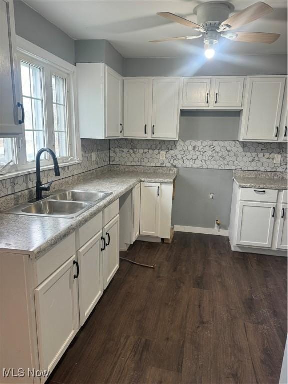 kitchen featuring white cabinets, backsplash, and a sink