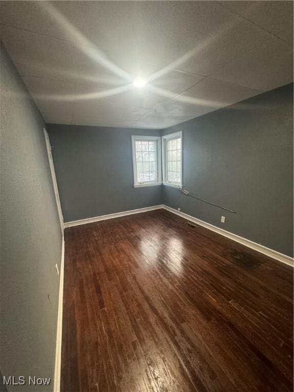 unfurnished room featuring baseboards and wood finished floors