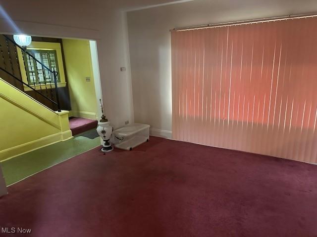 13705 Graham Ave, Cleveland, OH 44112 - unfurnished living room with carpet floors, stairs, and baseboards