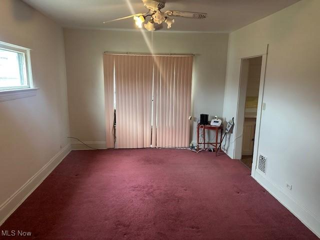 13705 Graham Ave, Cleveland, OH 44112 - carpeted empty room featuring baseboards, visible vents, and a ceiling fan