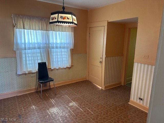 13705 Graham Ave, Cleveland, OH 44112 - unfurnished room with a wainscoted wall, baseboards, wallpapered walls, and tile patterned floors