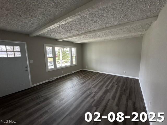 entrance foyer with a textured ceiling, visible vents, baseboards, beam ceiling, and dark wood finished floors